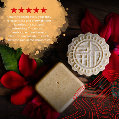 Eps bee hive-shaped soap bar and square soap on wooden surface with red flowers and green leaves