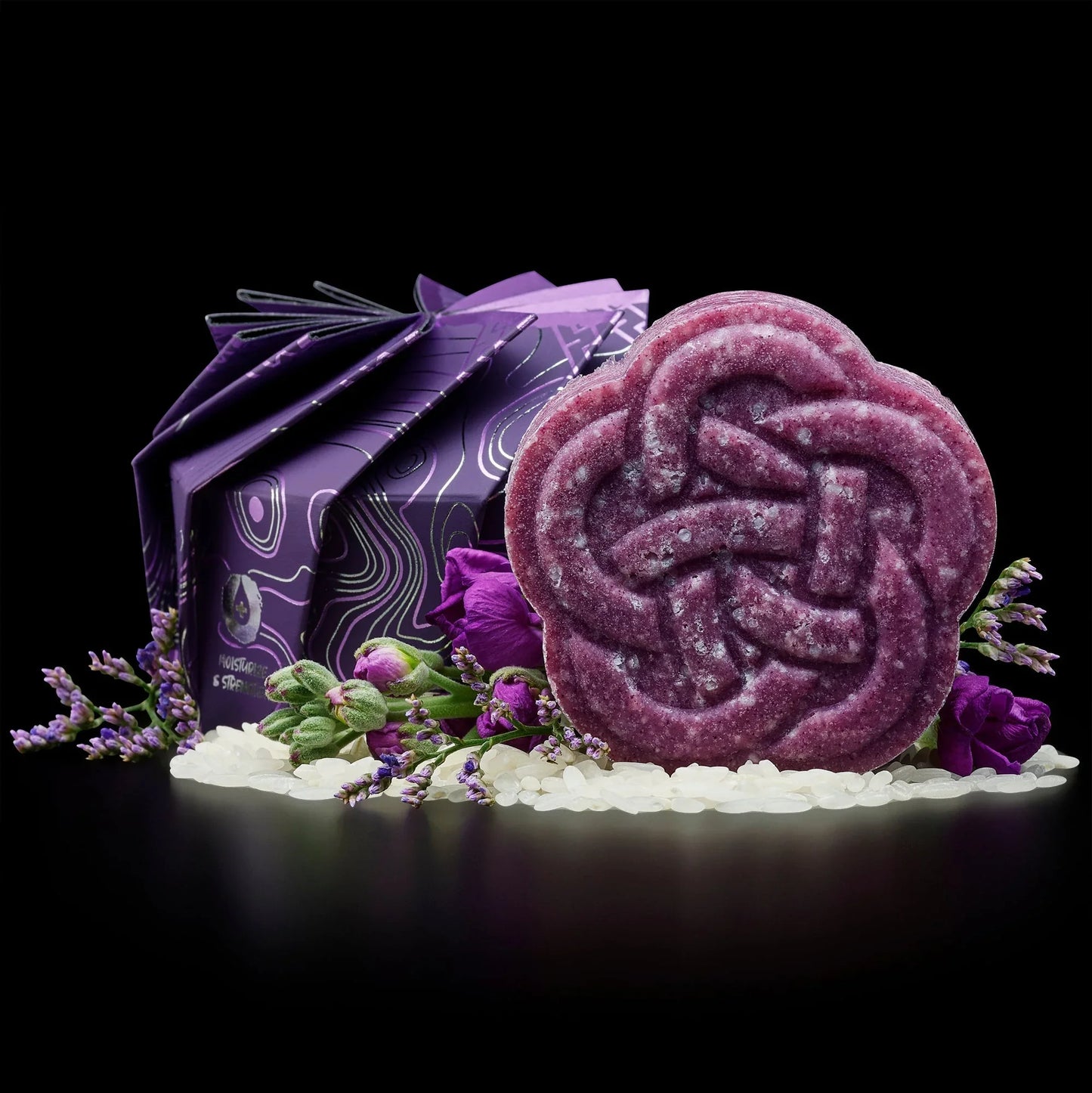 Purple EPS bee hive-shaped soap with floral packaging, surrounded by purple flowers and white beads