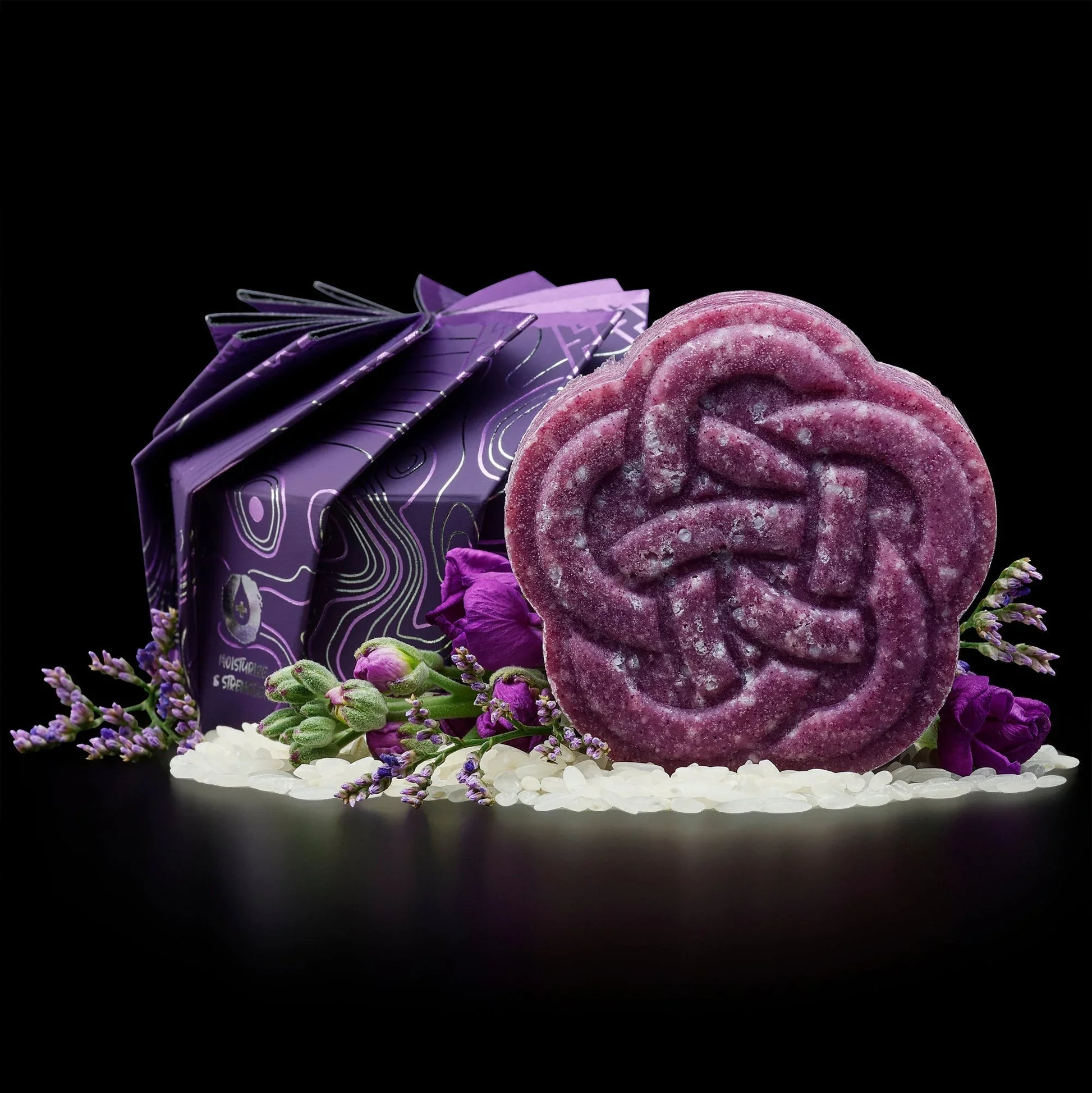 Purple EPS bee hive-shaped soap with floral packaging, surrounded by purple flowers and white beads