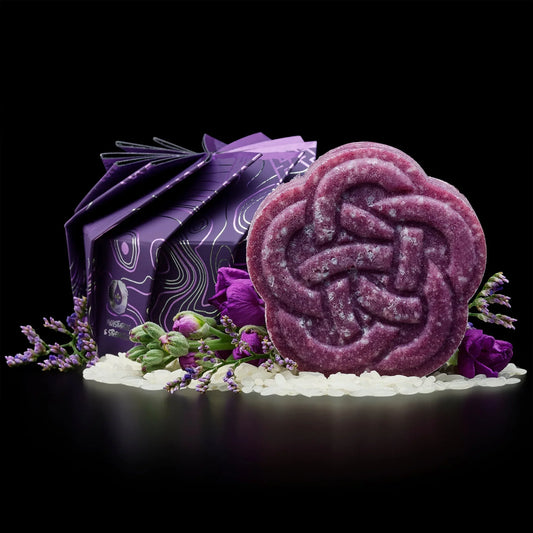Purple EPS bee hive-shaped soap with floral packaging, surrounded by purple flowers and white beads