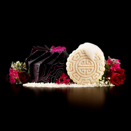 EPS bee hive-shaped shampoo bar with foam, surrounded by rice grains and vibrant flowers on black background