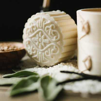 Close-up of an eps bee hive with intricate floral design surrounded by natural herbs and grains on wooden surface