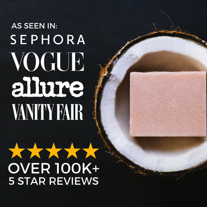 Pink moisturizing and repair conditioner bar displayed inside a halved coconut, black background, featured in Sephora, Vogue, Allure, and Vanity Fair with 100k+ five-star reviews