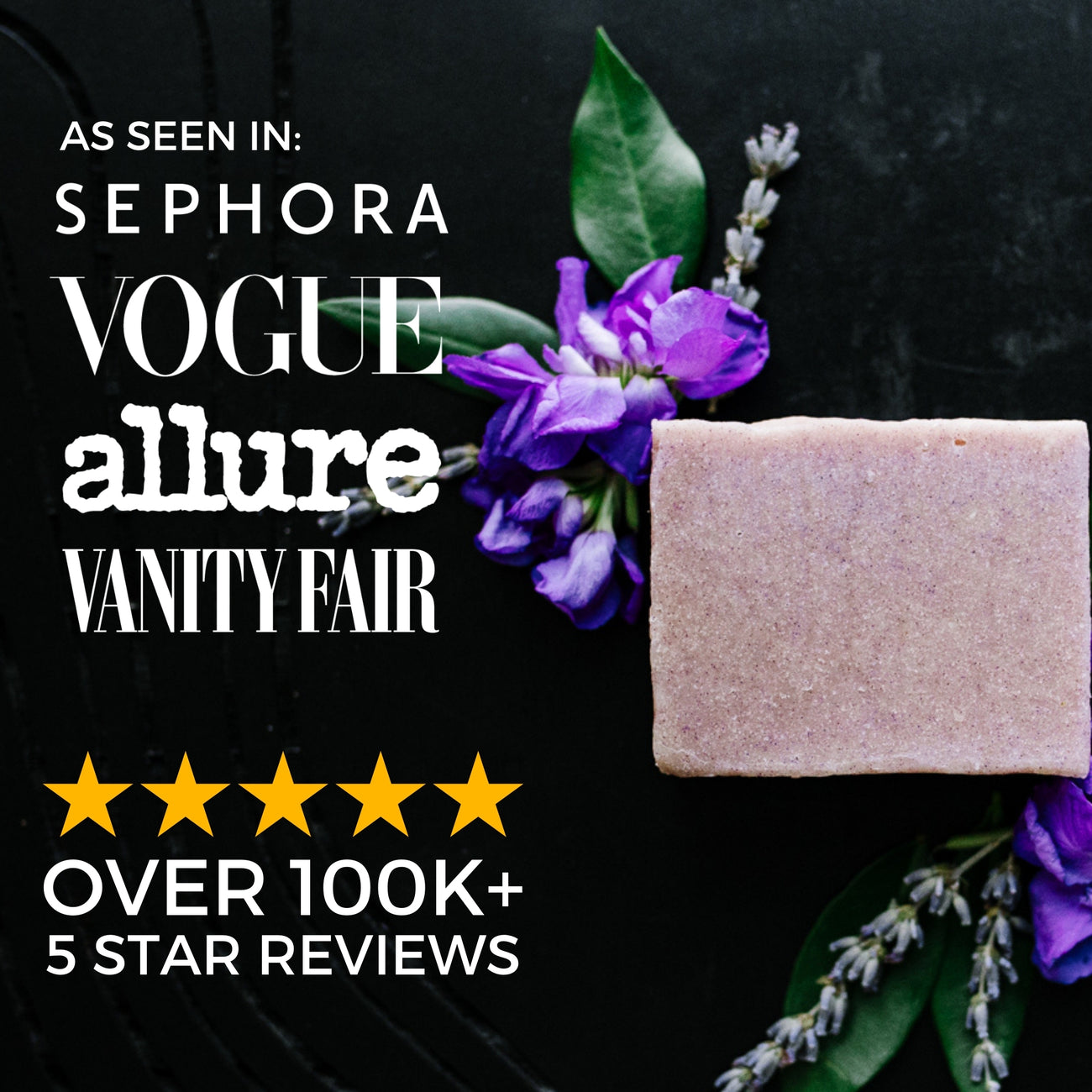 Natural soap bar on black background with purple flowers and green leaves, featured in top lifestyle magazines